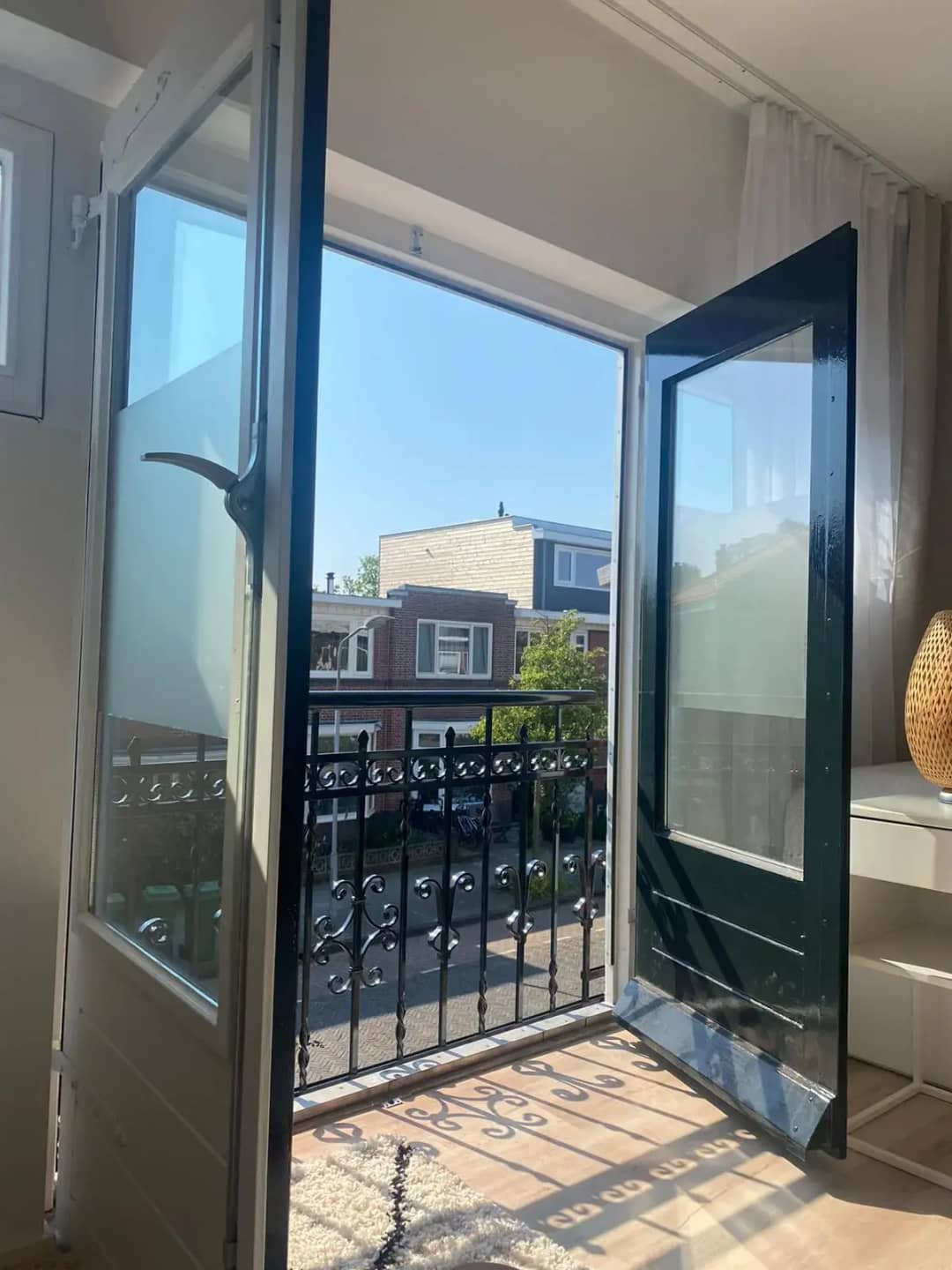 Stalen frans balkon hekwerk voor openslaande deuren vanaf binnenkant huis gezien